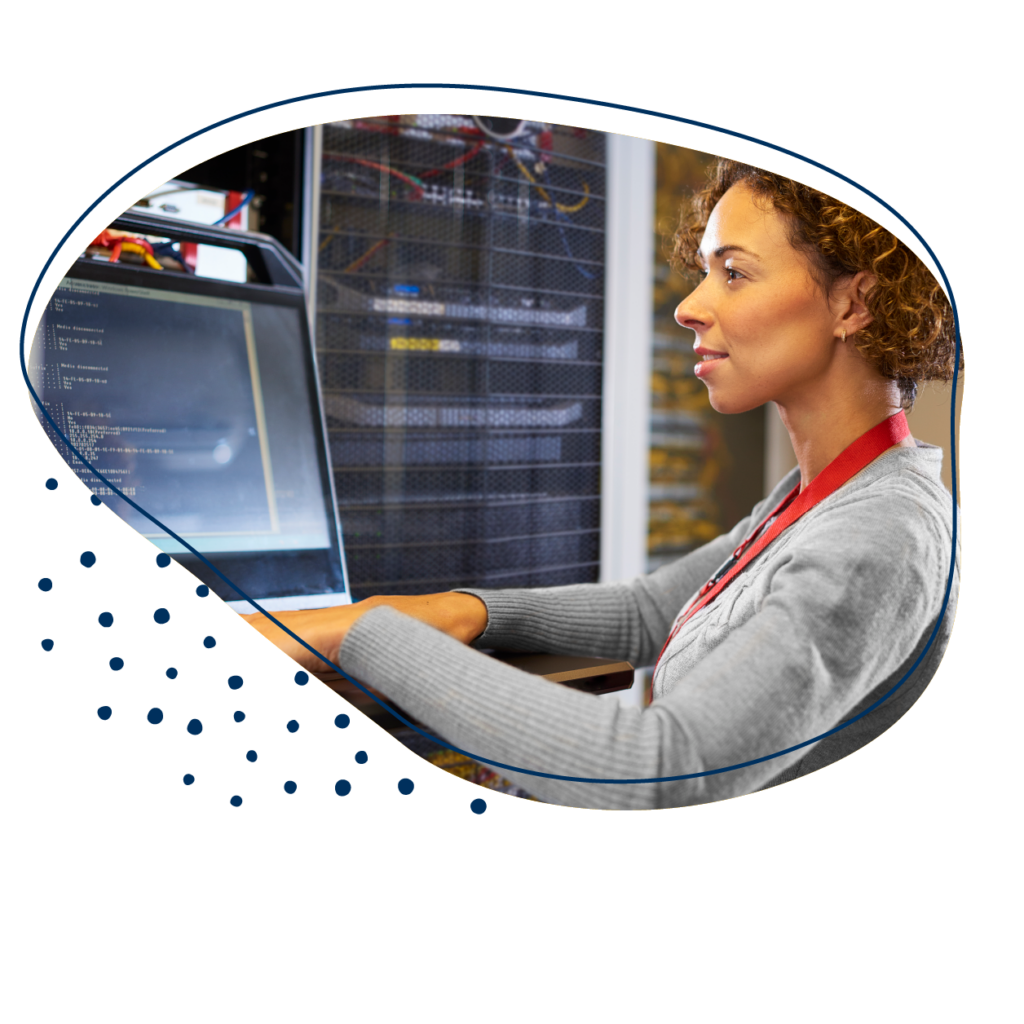 IT-Technikerin mit lockigen Haaren bedient einen PC in einem Rechenzentrum.