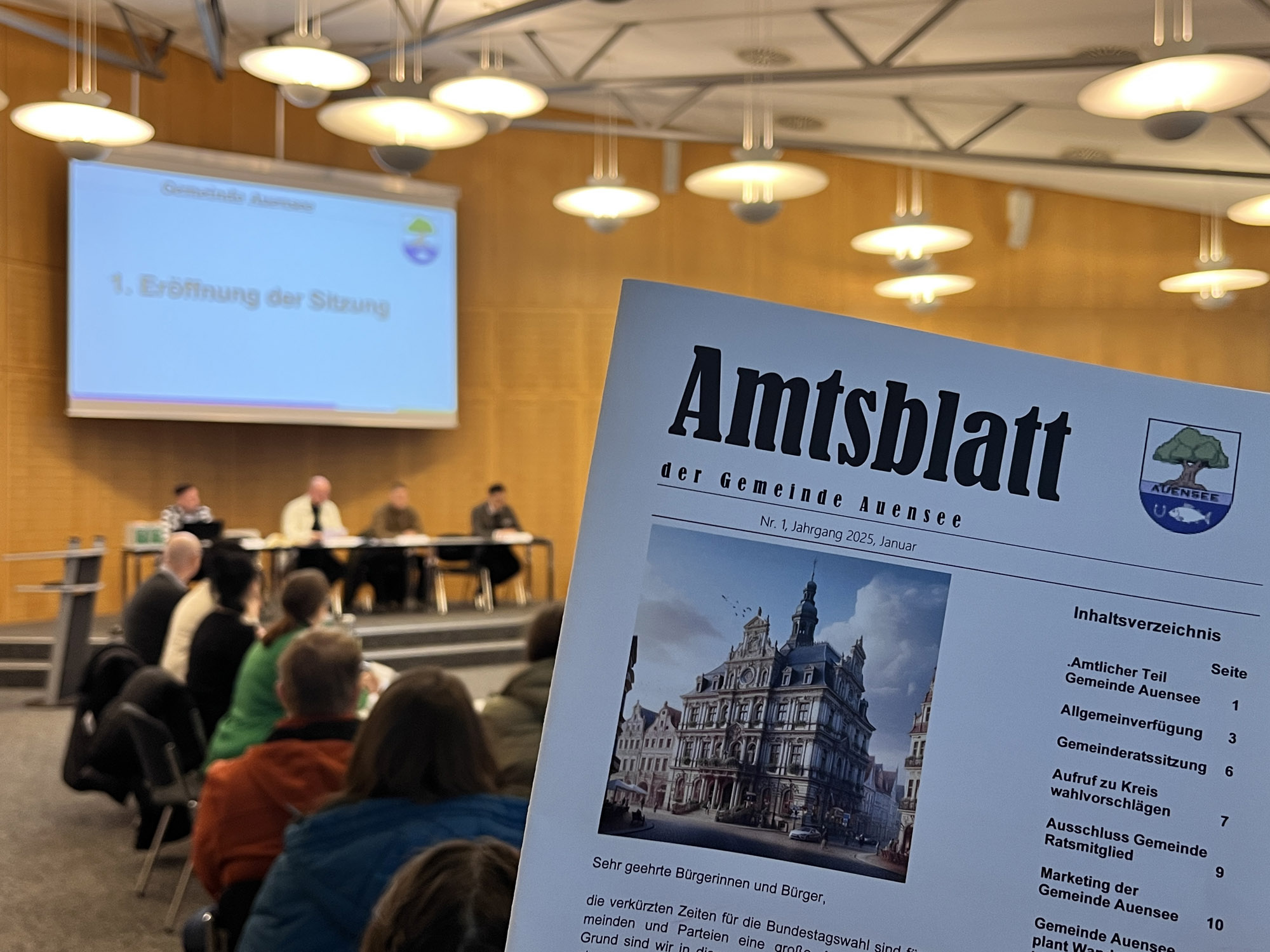 Nahaufnahme des Amtsblatt der Gemeinde Auensee (Lernbehörde im BFW Leipzig). Im Hintergrund ist unscharf die Eröffnung der Gemeinderatsitzung vom 06. Februar 2025 zu sehen.